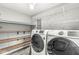 Updated laundry room with washer and dryer and plenty of shelving for storage at 5465 Leone Dr, Indianapolis, IN 46226
