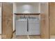 Laundry room with white washer and dryer units, wooden doors, and a storage shelf at 613 Brook Dr, Greenwood, IN 46143