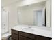 Bright bathroom with a vanity and integrated sink and mirror, next to a separate room with a tub/shower at 7161 Jackson Dr, Cumberland, IN 46229