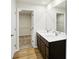 Bathroom featuring a double sink vanity, a large mirror, and a door leading to a walk-in closet at 7161 Jackson Dr, Cumberland, IN 46229