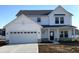 Charming two-story home showcasing a white exterior, attached garage, and well-manicured lawn at 7161 Jackson Dr, Cumberland, IN 46229