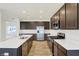 Sleek kitchen features stainless steel appliances, an island with a sink, and dark wood cabinets at 7161 Jackson Dr, Cumberland, IN 46229