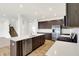 Modern kitchen boasts stainless steel appliances, dark wood cabinetry, and an island with a sink at 7161 Jackson Dr, Cumberland, IN 46229