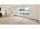 Carpeted living room with a view of the backyard through sliding glass doors and a large window at 7161 Jackson Dr, Cumberland, IN 46229