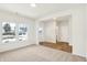Sunlit living room with neutral carpet, large windows, and open access to the entryway and bathroom at 7161 Jackson Dr, Cumberland, IN 46229