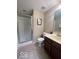 Traditional bathroom featuring a shower with glass doors, dark vanity, and neutral colored walls at 9506 Oakley Dr, Indianapolis, IN 46260