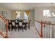 Elegant dining area adjacent to the staircase, bathed in natural light from large windows at 9506 Oakley Dr, Indianapolis, IN 46260