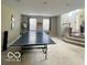 Spacious game room showcasing a ping pong table, carpeted floors, and access to the foyer at 9506 Oakley Dr, Indianapolis, IN 46260