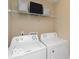 Functional laundry room with a washer, dryer, and overhead storage for convenience at 9506 Oakley Dr, Indianapolis, IN 46260