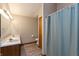 Bathroom with double sinks, a light fixture, and a shower with a patterned curtain at 10156 Park Royale Dr, Indianapolis, IN 46229