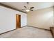 Neutral bedroom with ceiling fan, carpet, and a door leading to a bathroom at 10156 Park Royale Dr, Indianapolis, IN 46229