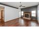 Open living room with hardwood floors, a ceiling fan, and a cozy brick fireplace at 10156 Park Royale Dr, Indianapolis, IN 46229