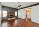 Open living room with hardwood floors, a ceiling fan, and a cozy brick fireplace at 10156 Park Royale Dr, Indianapolis, IN 46229