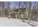 Side view of the two-story home featuring an attached garage and a quaint wooded lot at 1032 E Woodall Ct, Martinsville, IN 46151