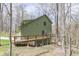 Exterior of the home featuring a deck with stairs down to yard, nestled among tall trees at 1032 E Woodall Ct, Martinsville, IN 46151