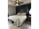 A primary bedroom boasts a dark accent wall, ceiling fan, stylish bedding, and a large window at 1130 W State Road 42, Mooresville, IN 46158