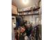 Storage room with shelves stocked with cleaning and painting supplies, as well as clothes and cleaning equipment at 1130 W State Road 42, Mooresville, IN 46158
