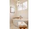 Bright bathroom featuring a freestanding tub with a brass faucet and a decorative chandelier at 15432 Heatherbank Dr, Westfield, IN 46074