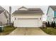 Two-car garage featuring white doors, carriage lights, and a well-maintained driveway at 15432 Heatherbank Dr, Westfield, IN 46074