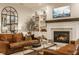 Bright living room boasts a fireplace, custom built-in shelves, and comfortable leather sofas at 15432 Heatherbank Dr, Westfield, IN 46074