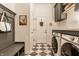 Mudroom with checkered floors, a bench with hooks, and modern washer and dryer units at 15432 Heatherbank Dr, Westfield, IN 46074