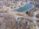 Aerial view of a home's location next to a serene pond, nestled within a wooded community at 15921 Herriman Blvd, Noblesville, IN 46060
