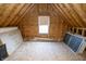 Unfinished attic space with exposed beams, plywood walls, and a window, ready for customization at 15921 Herriman Blvd, Noblesville, IN 46060