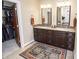 Bathroom with dual sinks, a vanity, decorative rug and access to the closet at 15921 Herriman Blvd, Noblesville, IN 46060