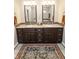 Bathroom with dual sinks, dark cabinetry, and a decorative rug at 15921 Herriman Blvd, Noblesville, IN 46060