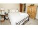 Comfortable bedroom featuring a bed with decorative pillows, side table, and a decorative armoire at 15921 Herriman Blvd, Noblesville, IN 46060
