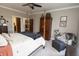 Well-lit bedroom with a four poster bed, ceiling fan and sitting area at 15921 Herriman Blvd, Noblesville, IN 46060