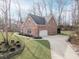 Side view of a beautiful brick home with an attached garage and pristine landscaping at 15921 Herriman Blvd, Noblesville, IN 46060