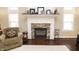 Close up of fireplace with decorative mantle and an armchair by the fireplace at 15921 Herriman Blvd, Noblesville, IN 46060