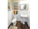 Charming powder room with pedestal sink, wainscoting, and hardwood floors at 15921 Herriman Blvd, Noblesville, IN 46060
