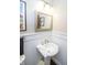 Bright powder room featuring wainscoting and a pedestal sink with modern fixtures at 15921 Herriman Blvd, Noblesville, IN 46060