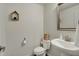 Compact bathroom featuring a toilet, sink, mirror, and decorative shelf with neutral wall color at 16057 Coleman Dr, Westfield, IN 46074