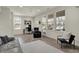 Bright living room featuring gray flooring, large windows, seating, work space and a ceiling fan at 16057 Coleman Dr, Westfield, IN 46074