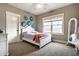 A bright bedroom featuring a bed with a pink blanket, a mirror, and a ceiling fan at 16882 Oak Manor Dr, Westfield, IN 46074