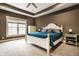 A bright, neutral bedroom featuring a large bed, a ceiling fan, and lots of natural light from the large window at 16882 Oak Manor Dr, Westfield, IN 46074