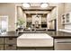 Kitchen island featuring a farmhouse sink, with views to an open living room, and lots of natural light at 16882 Oak Manor Dr, Westfield, IN 46074