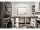 Modern laundry room featuring stacked washer and dryer units, ample counter space, and stylish tile flooring at 16882 Oak Manor Dr, Westfield, IN 46074