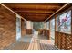 A covered back porch with brick, wood latticework, and an American flag at 1901 E Edgewood Ave, Indianapolis, IN 46227