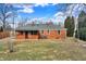Rear exterior view showing the brick home, the yard, and covered back porch at 1901 E Edgewood Ave, Indianapolis, IN 46227