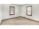 Well-lit bedroom with neutral carpet, two windows and wood trim throughout at 1901 E Edgewood Ave, Indianapolis, IN 46227