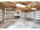The garage has an open ceiling with a concrete floor and shelving, providing ample storage space at 1901 E Edgewood Ave, Indianapolis, IN 46227