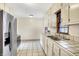 Functional kitchen with ample cabinet space, tile countertops, and stainless steel refrigerator at 1901 E Edgewood Ave, Indianapolis, IN 46227