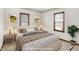 Staged bedroom with a large bed, matching nightstands, and two windows at 1901 E Edgewood Ave, Indianapolis, IN 46227