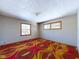 Bright bedroom with neutral walls, two windows, and a unique, colorful carpet at 2021 E 9Th St, Anderson, IN 46012