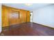 Bedroom featuring wood-paneled walls, built-in shelves, and a door leading to another room at 2021 E 9Th St, Anderson, IN 46012