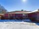 Well-maintained single-story home with mature bushes, and a snow covered lawn at 2021 E 9Th St, Anderson, IN 46012